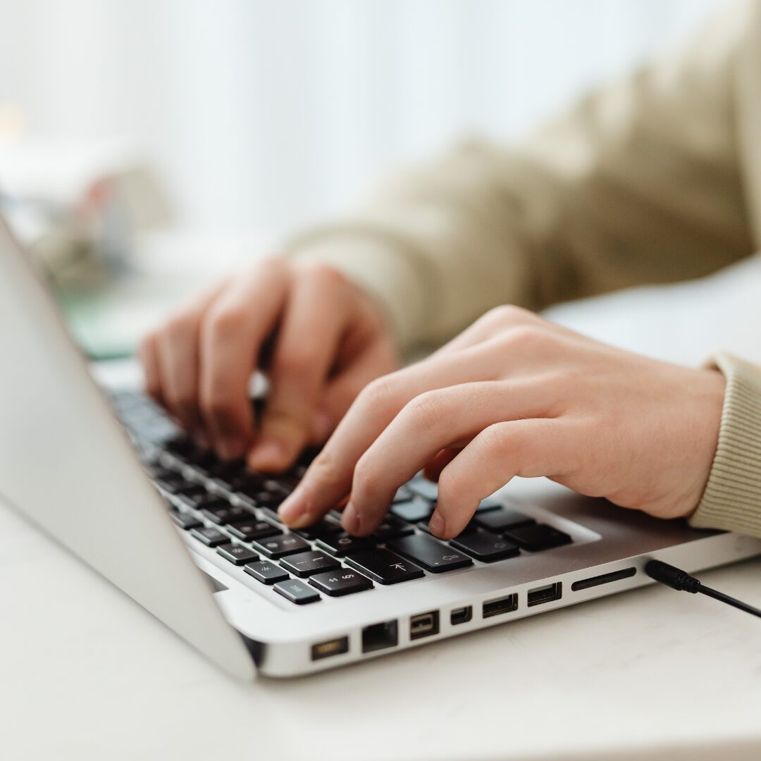 Person typing on a laptop searching up a domain name.