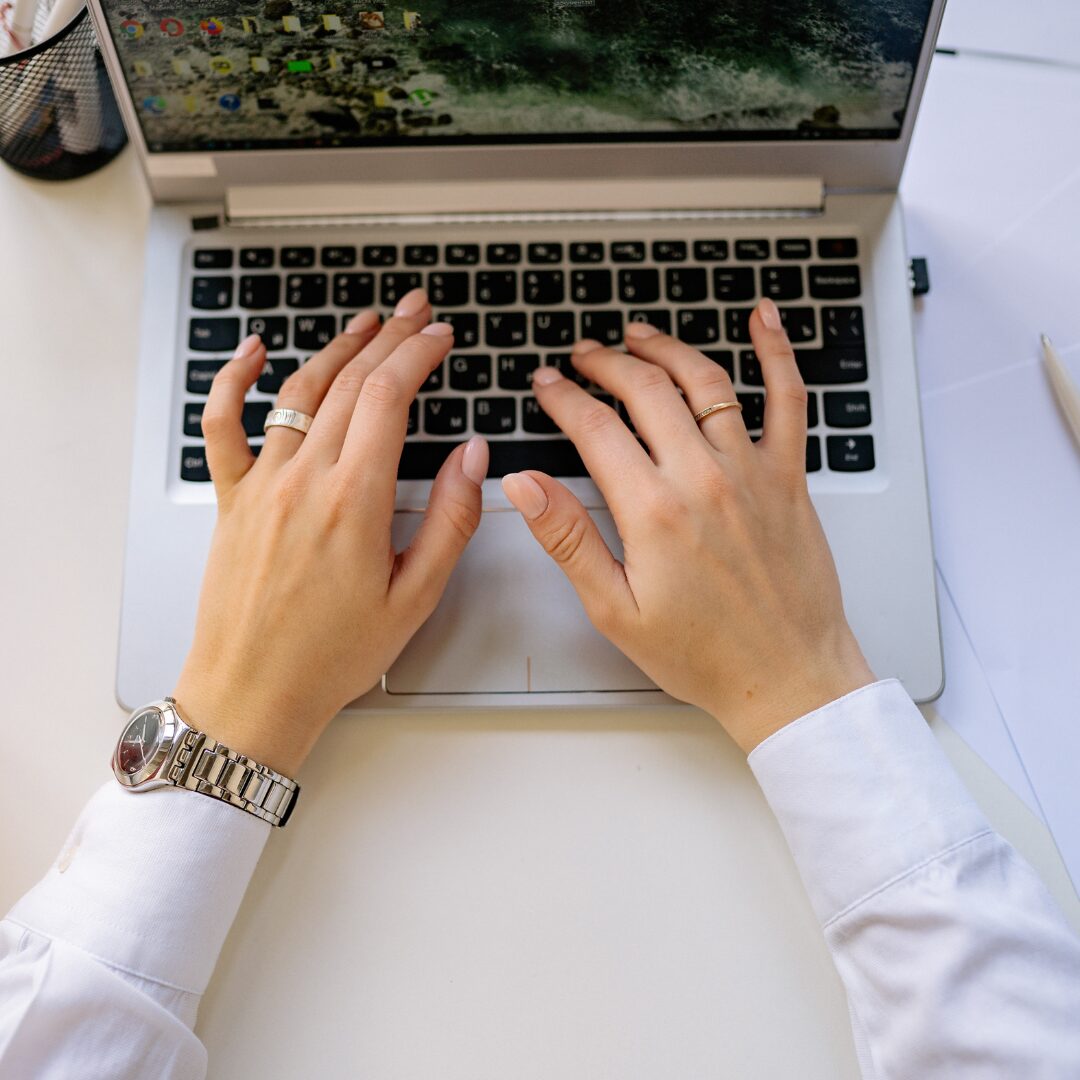 hands typing on a laptop searching up domain extensions.