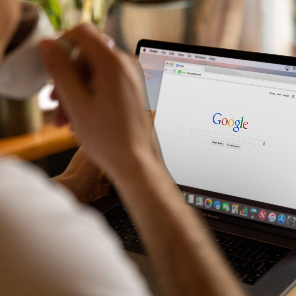 Person drinking coffee looking at a Google Home Page about to work on SEO.
